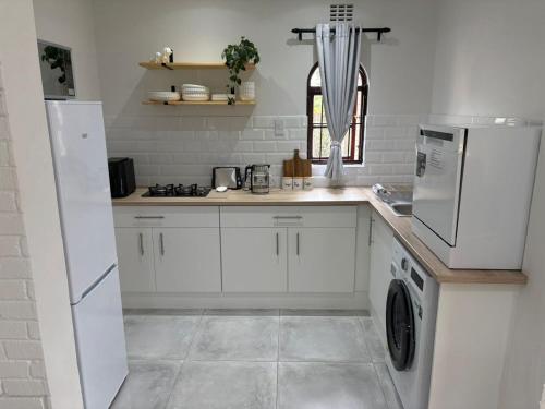 a kitchen with white cabinets and a washer and dryer at 19 on Amber in Ugie