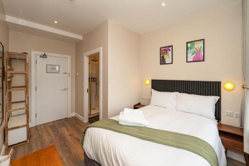 a bedroom with a large bed with white sheets at Wee Sleep Ireland in Derry Londonderry