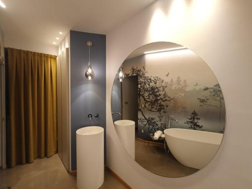 a bathroom with a large mirror and a tub at HOTEL - BAR DA NATALE in Paesana