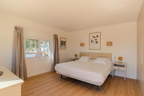 a bedroom with a white bed and a window at Villa Can Ferrer in the centre of Cala dOr in Cacla D'or
