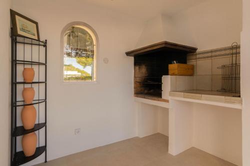 a kitchen with an oven and a window and shelves at Villa Can Ferrer in the centre of Cala dOr in Cacla D'or