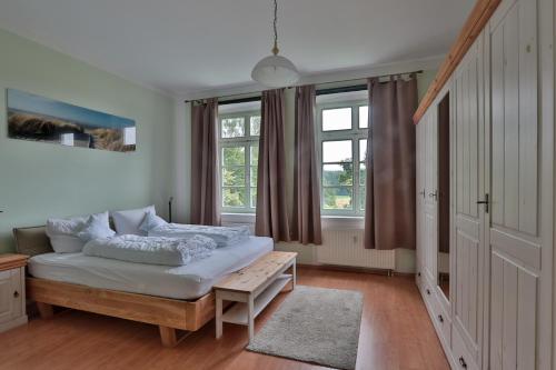a bedroom with a bed in a room with windows at Herrenhaus Blengow App.08 in Blengow
