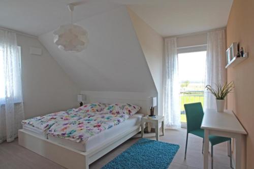a bedroom with a bed and a desk and a window at Maison du Bonheur in Rerik
