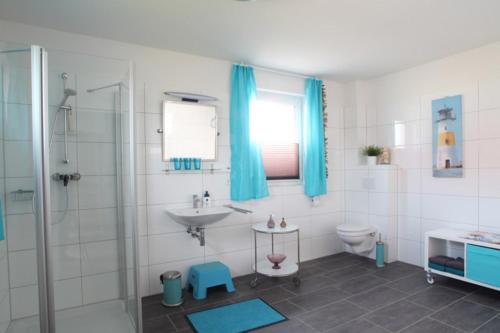 a bathroom with a sink and a toilet and a shower at Maison du Bonheur in Rerik