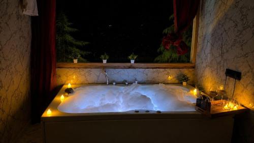 a bath tub with lights in a room with a window at The Woodnest Tandi in Jibhi