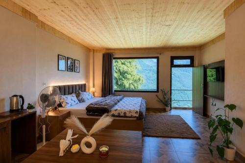a bedroom with a bed and a large window at The Woodnest Tandi in Jibhi