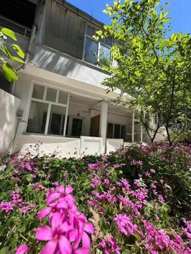 a pile of pink flowers in front of a house at Kalemi Pansiyon in Marmara