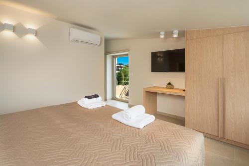 a bedroom with a bed with two white towels at La Divina Luxury Villas with Heated Pool in Daratso