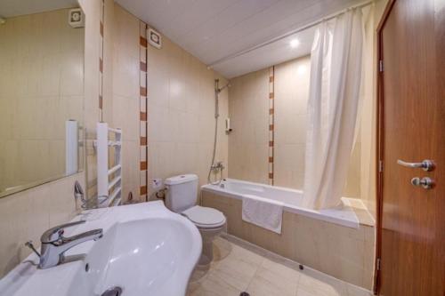 a bathroom with a sink and a toilet and a tub at Dafovska Hotel in Pamporovo