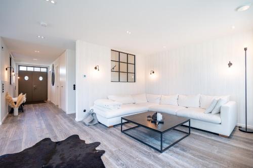 a living room with a white couch and a table at Reetidyll am Haff - Haus 2 in Stolpe auf Usedom