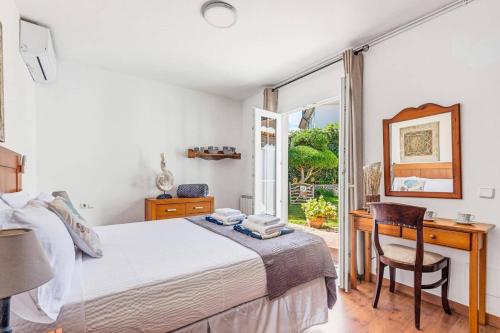 a bedroom with a bed and a desk and a window at Villa Tamyan by Villa Plus in Son Parc