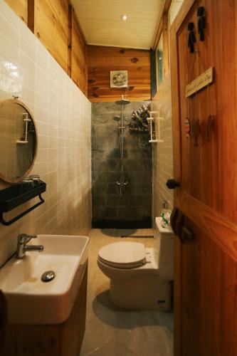 a bathroom with a shower and a toilet and a sink at À La Main Farmhouse in Ấp Trường Sơn