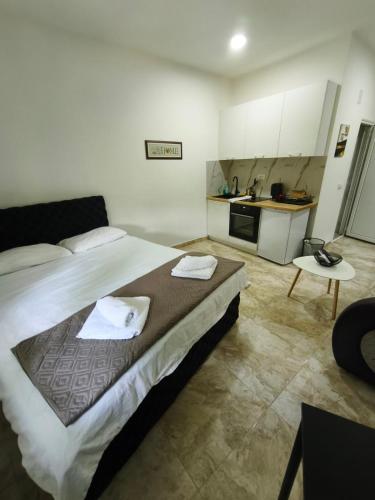 a bedroom with a large bed and a kitchen at Rea Apartments in Belgrade