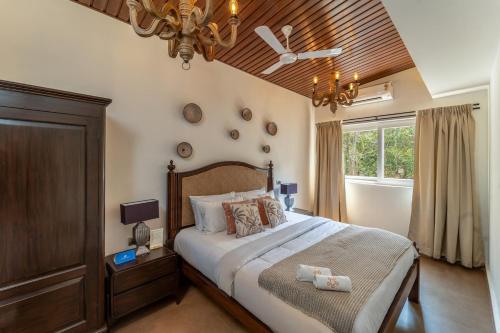 a bedroom with a large bed and a window at SaffronStays Forest Edge in Siolim