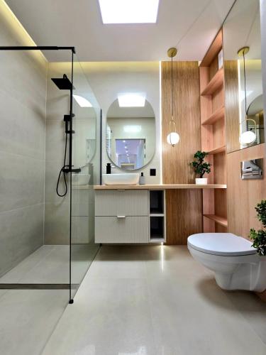 a bathroom with a toilet and a mirror at Apartament Ostródzka in Iława