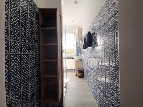 a bathroom with a black tile wall and a hallway at Euer Ferienheim in Senftenberg