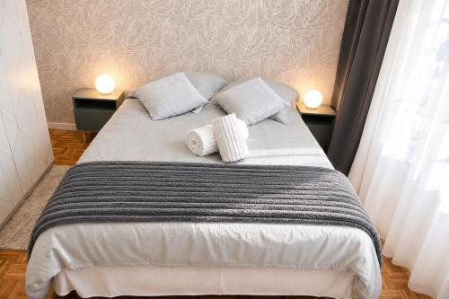 a bedroom with a bed with two pillows on it at Le Mans Cosy in Le Mans
