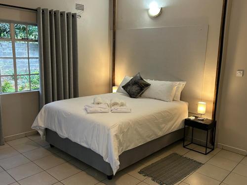 a bedroom with a bed with towels on it at Hungwe House in Victoria Falls