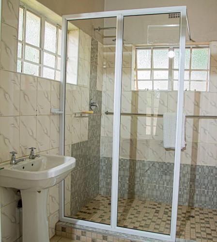 a bathroom with a shower and a sink at Hungwe House in Victoria Falls