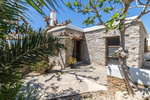 a small stone house with a statue on top of it at Liostasi Tinos in Agios Fokas