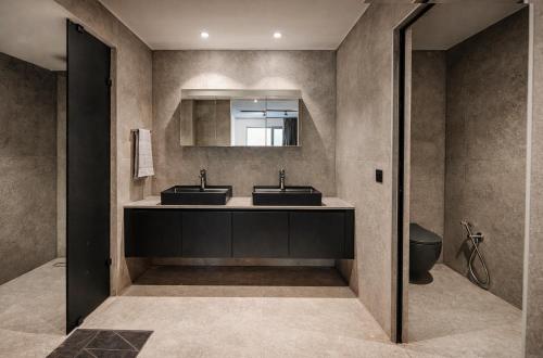 a bathroom with two sinks and a mirror at Nerea Residences in Schinias