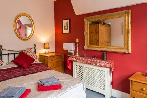 a red bedroom with a bed and a mirror at Vintage 2-bed flat with free parking in Measham in Measham