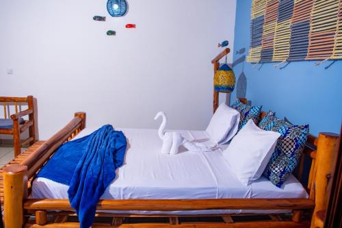 a bedroom with a wooden bed with blue walls at Telvina Beach Lodge in Vilanculos