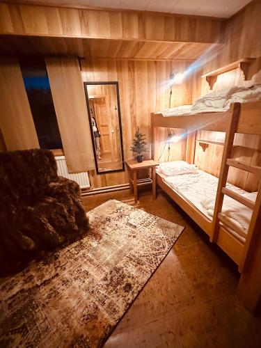 a bedroom with two bunk beds and a rug at Hotelletvidfjallet in Transtrand