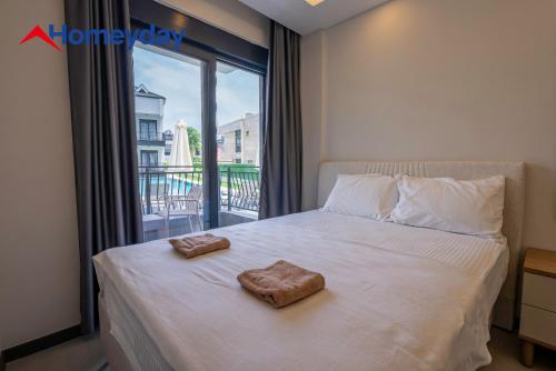 a bedroom with a bed with two towels on it at Whitestone Homes in Antalya