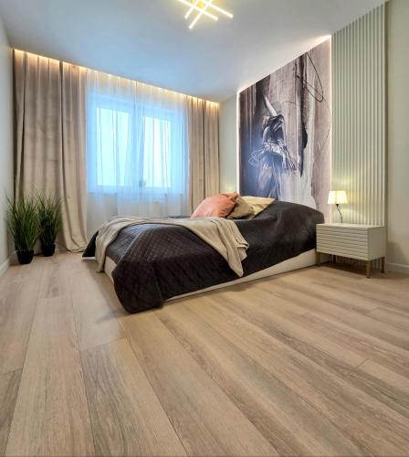 a bedroom with a bed and a painting on the wall at Apartament Ostródzka in Iława