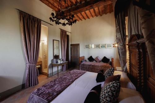 a hotel room with two beds and a bedroom with at Castello Di Tornano Wine Relais in Gaiole in Chianti