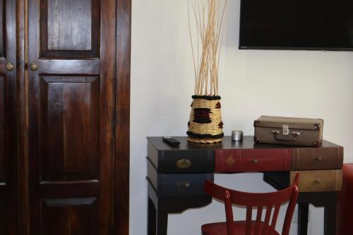 a desk with a chair next to a table with a suitcase at Sabbia e Coralli in Muravera