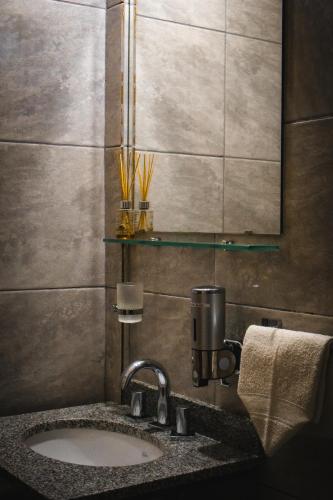 a bathroom with a sink and a mirror at Piedra Alta Hotel & Restaurante in Itá Ibaté