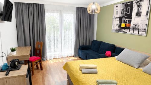 a bedroom with a yellow bed and a blue couch at Ruciane Tarasy in Ruciane-Nida