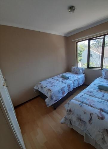 a bedroom with two beds and a window at Elikia in Pretoria