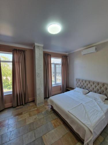 a bedroom with a large bed and windows at Silver room 3 in Zatoka