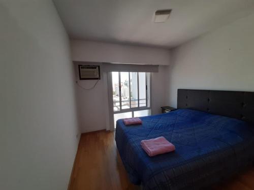a bedroom with a blue bed and a window at Parana in Rosario