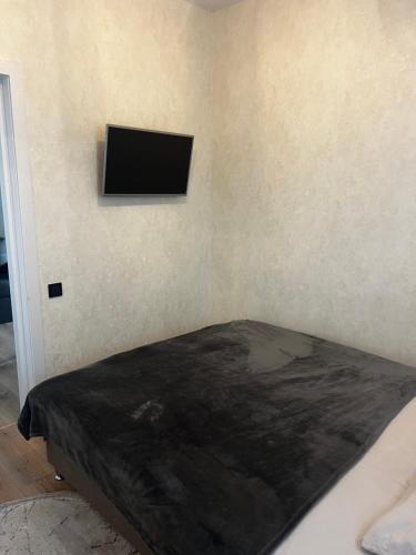 a bedroom with a bed with a television on the wall at Anna in Rivne