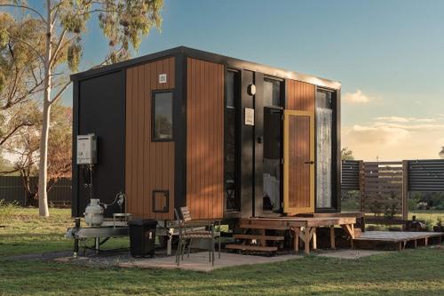 a tiny house with a picnic table and a bench at D&L Cottage by Tiny Away in Kudla