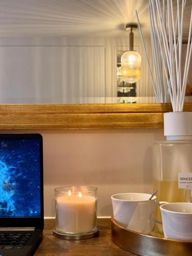 a laptop sitting on a table with candles and cups at Number 3 Pier Road Suites in Whitby