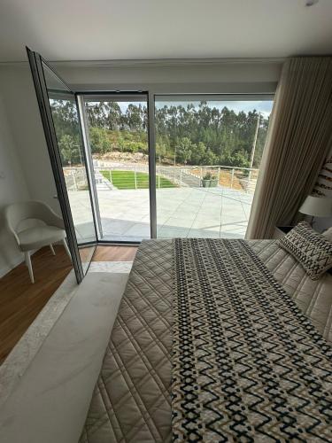 a bedroom with a large bed and a large window at Apartamento AC T2 Pombal in Pombal