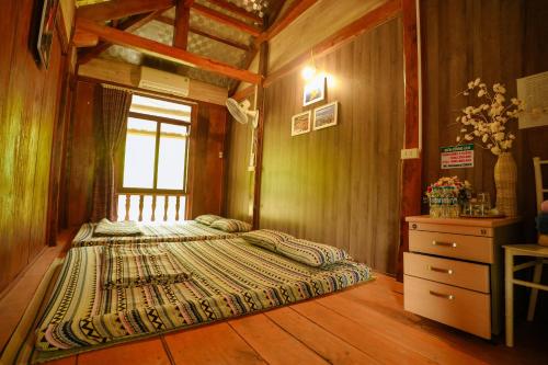 a bedroom with a large bed and a window at Mây farmstay in Ðà Bắc