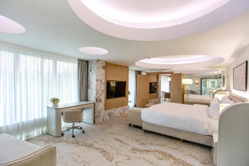 a hotel room with a large bed and a television at Almaty Hotel in Almaty