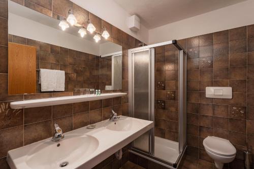 a bathroom with a sink and a shower and a toilet at Panorama Hotel St Georgen in Schenna