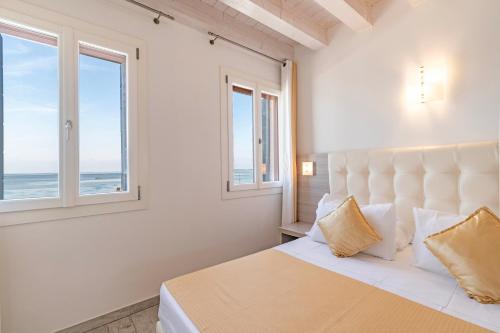 a bedroom with a bed with a view of the ocean at Locanda Stravedo in Pellestrina