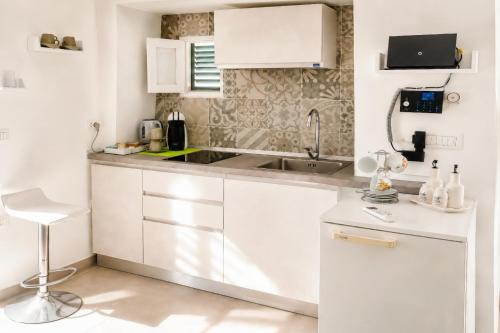 a kitchen with white cabinets and a sink at Venti Nodi in Vieste