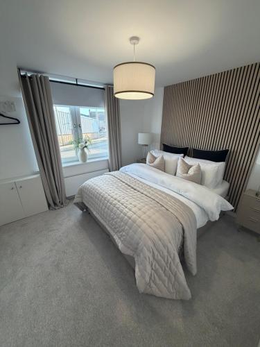 a bedroom with a large bed with a large window at The Esplanade Apartment in Peterhead