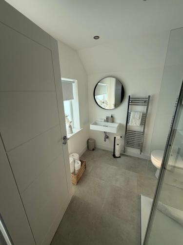 a bathroom with a sink and a mirror at The Esplanade Apartment in Peterhead
