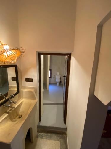 a bathroom with a sink and a mirror and a toilet at Hôtel bleu ciel in Aït Yous