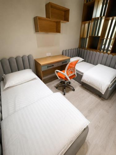 a room with three beds and a desk and a chair at Beshik Apartment 2 in Samarkand